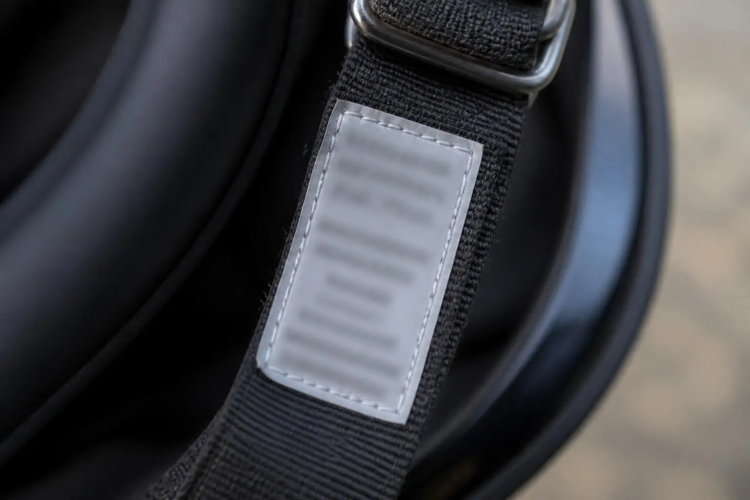 Prüfetikett am Kinnriemen eines Motorradhelms in Nahaufnahme.